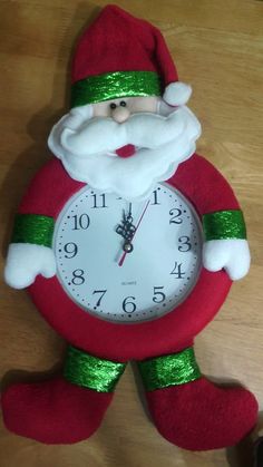 a santa clause clock with green sequins on it