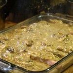 a glass casserole dish filled with food sitting on top of a wooden table