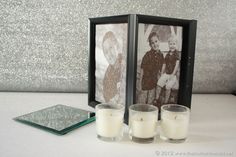 two candles are sitting next to an old photo