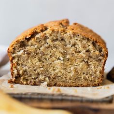 a loaf of banana bread sitting on top of a wooden cutting board