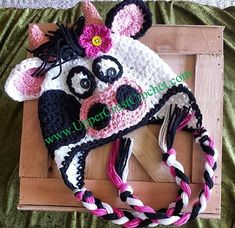 a crocheted cow hat on top of a wooden board