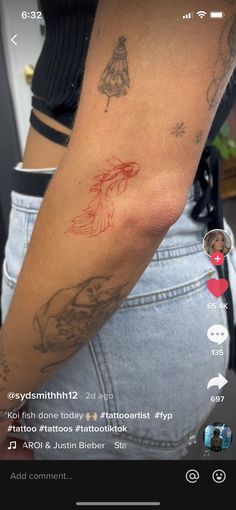 a woman's arm with tattoos on it and an image of a fish in the background