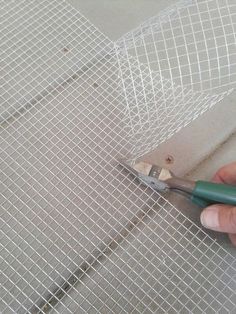 a person cutting through some mesh with scissors