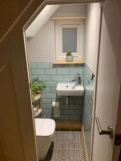 an open door leading to a bathroom with a sink and toilet in it's corner