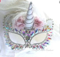 a masquerade mask with flowers and feathers on white fabric background for advertising purposes