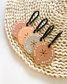 three brown and white tags with black handles on a woven place mat that says, welcome willow