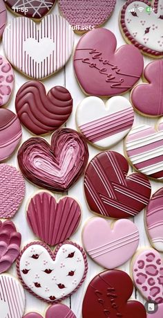 many heart shaped cookies are arranged on a white table top with pink and red icing