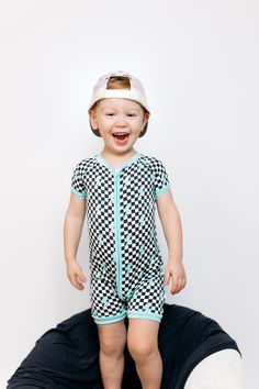 Get ready to electrify the room with our Be Electric Dream Shortie. This checkered print romper features a bold blue lightening design and is made with bamboo material for ultimate comfort. A short style adds a playful touch to this must-have piece. Shockingly stylish and oh-so-comfy! The Dream Shortie is the perfect way to seamlessly transition little ones to Summer. With an easy-access zipper feature (hello diaper changes) your little one will be comfy and looking cool! Who could ask for anyth Tuxedo Accessories, Toddler Flower Girls, Girls Gloves, Girls Dress Outfits, Toddler Flower Girl Dresses, Infant Flower Girl Dress, Bamboo Material, Tea Party Dress