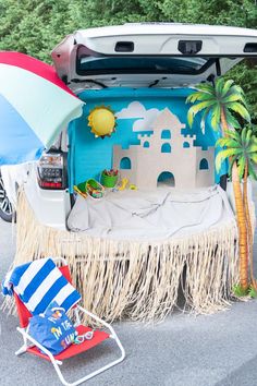 an open trunk of a car with a beach scene on the back and palm trees