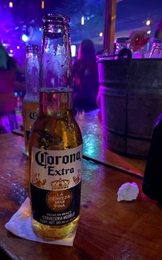 a beer bottle sitting on top of a table next to a glass filled with liquid