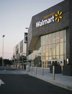 a walmart store is shown at dusk with the sun shining on the building and it's windows