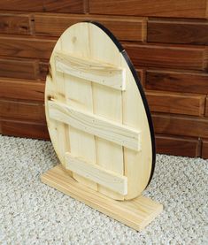 a wooden board with an oval design on it sitting in front of some wood planks