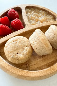 some raspberries and cookies on a wooden plate