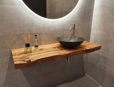 a bathroom sink sitting under a round mirror