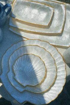 white dishes with gold trim sitting on a table