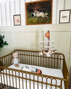 there is a baby crib in the room with pictures on the wall behind it