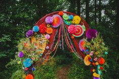 colorful paper fans and streamers decorate the entrance to a garden wedding ceremony in an outdoor setting