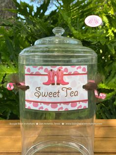 a glass jar filled with pink and brown tea sitting on top of a wooden table