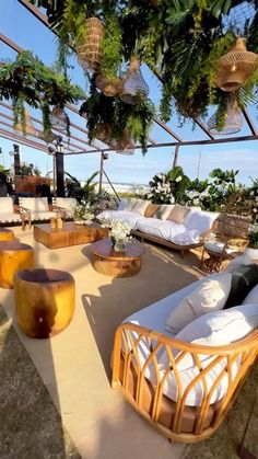 an outdoor seating area with wicker furniture and hanging plants on the roof top terrace