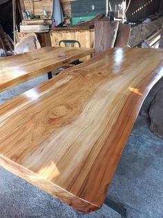 two tables made out of wood sitting in a room next to other wooden furniture and materials