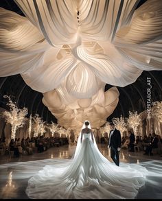 a bride and groom standing in front of an enormous white sculpture at their wedding reception