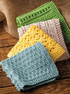 four crocheted dishcloths sitting on top of a wooden table next to burlocks