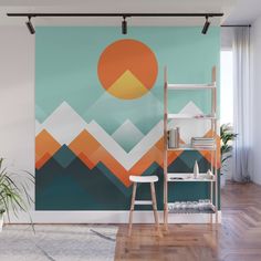 an abstract wall mural with mountains and sun in the sky, on a wooden floor