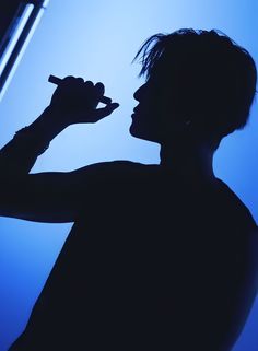 the silhouette of a man holding a microphone