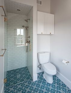 a white toilet sitting next to a walk in shower