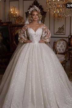 a woman in a wedding dress standing next to a chandelier