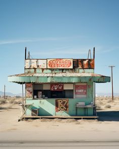 an old, run down gas station sits in the middle of nowhere on a desert plain