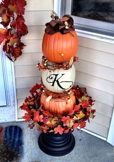 three pumpkins stacked on top of each other with the letter k painted on them