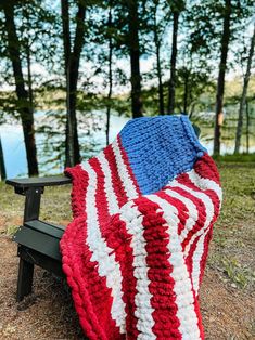 an american flag crocheted blanket on a park bench