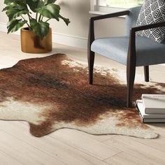 a brown and white area rug in a living room next to a chair with a plant on it