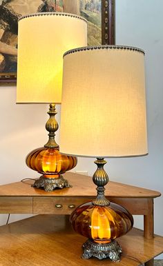 two lamps sitting on top of a wooden table