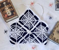 there is a crocheted spider web on the bed next to some books and other items