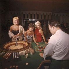 three women and two men playing roulejack in a casino