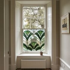 a white window with green leaves on it