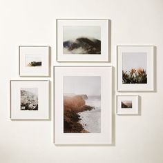 several pictures hanging on the wall with white frames