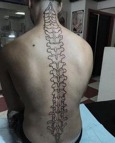 the back of a man's neck with a skeleton tattoo on it