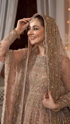 a woman in a bridal gown poses for the camera with her hand on her head