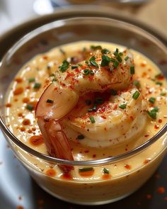 a bowl filled with shrimp and sauce on top of a table