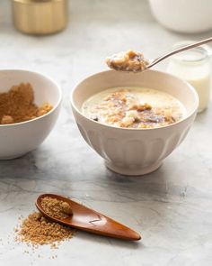 two bowls filled with oatmeal next to a spoon full of oats