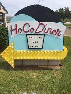 a sign that says hoo - dine welcomes locals to the area and is decorated with lights