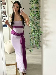 a woman taking a selfie with her cell phone in front of a mirror wearing a purple and white dress