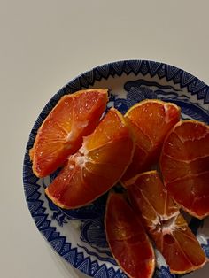 an orange cut in half on a blue and white plate