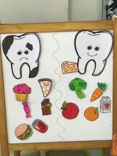 a white board with cutouts of tooth and food