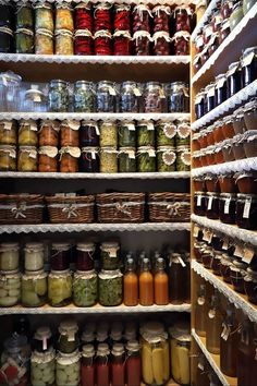 an open pantry filled with lots of different types of jars and sauces on shelves