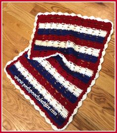 two red, white and blue crocheted afghans sitting on top of a wooden floor