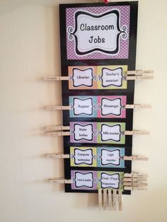 a classroom sign with clothes pins attached to it